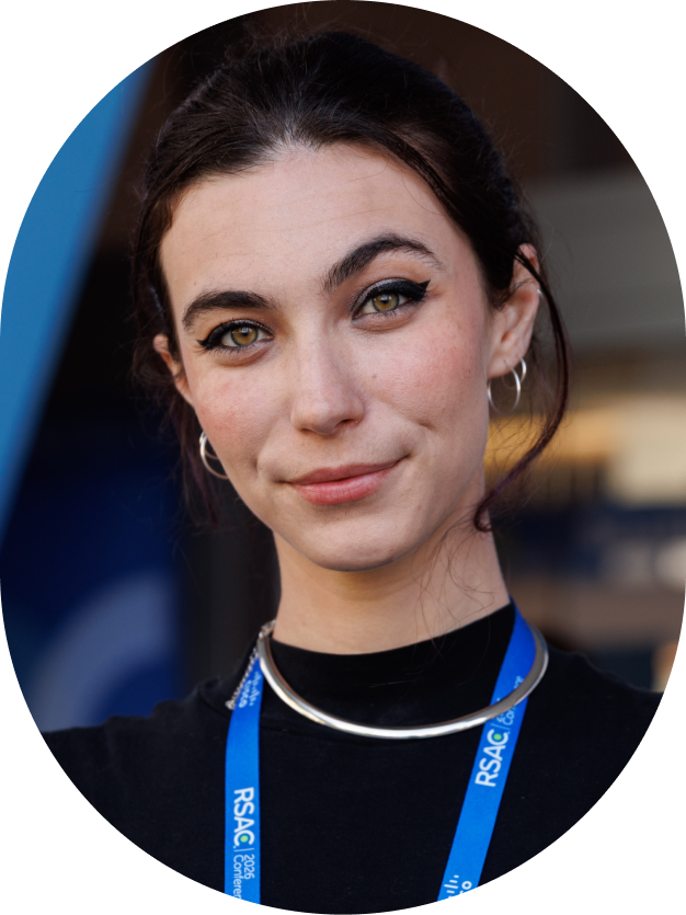 Woman with dark hair wearing a black top and blue RSAC conference lanyard.