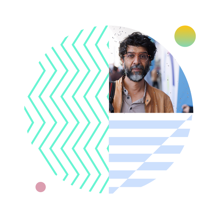 Man with glasses speaking during a virtual presentation, surrounded by teal zigzag patterns and blue geometric shapes.