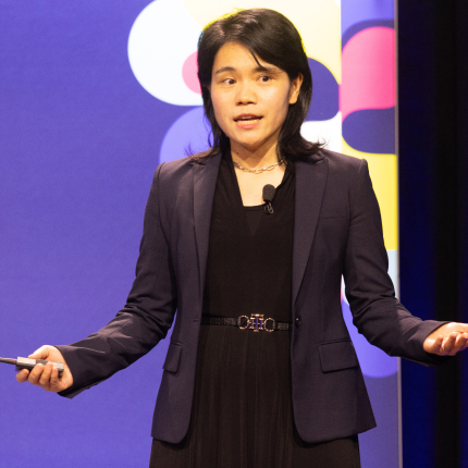 Female speaker presenting on stage, representing Culminate, a 2024 RSAC Launch Pad finalist acquired by Datadog.