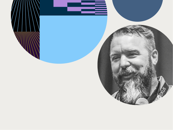 Black-and-white headshot of a smiling man with a long beard, surrounded by colorful geometric patterns.